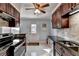Charming kitchen featuring dark wood cabinets, granite countertops, stainless steel appliances, and tile backsplash at 6118 Queen Anne Ct, Norcross, GA 30093