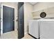 Laundry room featuring a washer, dryer, wire shelving, tile flooring, and access to the exterior at 380 Vista Creek Dr, Stockbridge, GA 30281