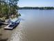 Aerial view of a boat dock on a lake with a covered boat slip, surrounded by trees and calm water at 455 Mayo Rd, Covington, GA 30014