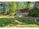 A large backyard with a covered porch, garden beds, and lush greenery at 455 Mayo Rd, Covington, GA 30014