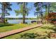 Manicured backyard leading to a tranquil lake with a wooden walkway to a private boat dock at 455 Mayo Rd, Covington, GA 30014
