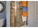 Bathroom featuring a glass door shower, a wall-mounted towel rack with blue and orange towels, and a round mirror at 455 Mayo Rd, Covington, GA 30014
