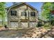 Charming home exterior boasting a three-car garage with white doors and lush green surroundings at 455 Mayo Rd, Covington, GA 30014