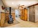 Rustic living area with a decorative wood-burning stove and a sliding barn door at 455 Mayo Rd, Covington, GA 30014