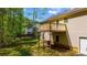 View of backyard with a small deck and mature trees surrounding the property at 379 Villa Rosa Way, Temple, GA 30179