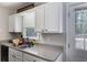 Kitchen area with white cabinets, stainless steel sink, and natural light from a window at 379 Villa Rosa Way, Temple, GA 30179