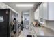 Well-lit kitchen with black appliances and a view of the laundry room at 379 Villa Rosa Way, Temple, GA 30179