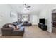 Spacious living room featuring a TV, comfortable gray sectional sofa, and access to an adjacent bedroom at 379 Villa Rosa Way, Temple, GA 30179