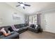 Cozy living room features a comfortable gray sectional sofa, plush carpet, and ample natural light at 379 Villa Rosa Way, Temple, GA 30179