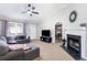 Inviting living room boasts a fireplace, gray sectional, TV, and seamless access to an adjacent bedroom at 379 Villa Rosa Way, Temple, GA 30179