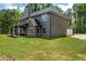 Large backyard featuring a well-maintained lawn, a covered patio, and a modern two-story home at 415 Paynes Lake Rd, Carrollton, GA 30116