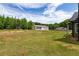 Expansive backyard featuring a large lawn and a detached garage or workshop, great for outdoor activities at 415 Paynes Lake Rd, Carrollton, GA 30116