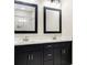 Modern bathroom boasts dual sinks with dark cabinets and brushed nickel hardware, illuminated by vanity lights at 415 Paynes Lake Rd, Carrollton, GA 30116