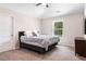 Comfortable bedroom featuring a large bed, side table, and a window with a view of the trees at 415 Paynes Lake Rd, Carrollton, GA 30116