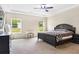 A spacious bedroom featuring a large bed, dresser, and two windows overlooking a lawn at 415 Paynes Lake Rd, Carrollton, GA 30116