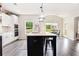 Bright kitchen with white cabinets, stainless steel appliances, a spacious island, and views of the backyard at 415 Paynes Lake Rd, Carrollton, GA 30116