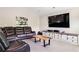 Large living room featuring a leather sectional, a TV, and a custom-built entertainment center at 415 Paynes Lake Rd, Carrollton, GA 30116