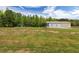 Large lot featuring a three-bay outbuilding, trampoline, garden, and abundant green trees at 415 Paynes Lake Rd, Carrollton, GA 30116