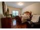 Cozy bedroom with hardwood floors, a queen bed, a leather arm chair and dresser at 4734 Eagles Ridge Loop, Lithonia, GA 30038