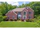 Charming two-story brick home featuring a well-manicured lawn and lush landscaping at 4734 Eagles Ridge Loop, Lithonia, GA 30038