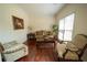 Cozy living room featuring hardwood floors, a window with blinds, and comfortable seating at 4734 Eagles Ridge Loop, Lithonia, GA 30038
