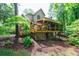 Beautiful backyard view featuring a deck, patio, lush landscaping, and mature trees offering shade and privacy at 745 Devon Hill Ct, Roswell, GA 30075