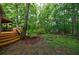 Spacious backyard showcasing a wooden deck, stairs, and a blend of natural greenery and maintained landscaping at 745 Devon Hill Ct, Roswell, GA 30075