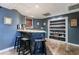 Basement bar area featuring a stone bar, stools, and display shelves at 745 Devon Hill Ct, Roswell, GA 30075