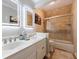 Bright bathroom featuring a double sink vanity and a glass-enclosed shower and bathtub combo at 745 Devon Hill Ct, Roswell, GA 30075