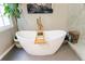 Soaking tub with bamboo shelf adjacent to glass walk-in shower, set on grey tile floor at 745 Devon Hill Ct, Roswell, GA 30075