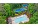 Aerial view of community amenities, including a pool and tennis courts, nestled among mature trees at 745 Devon Hill Ct, Roswell, GA 30075