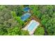 Aerial view of a community pool and tennis courts surrounded by lush greenery and mature trees at 745 Devon Hill Ct, Roswell, GA 30075