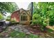 Charming home exterior with a blend of brick and siding, surrounded by mature trees and stone landscaping at 745 Devon Hill Ct, Roswell, GA 30075