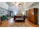 This main bedroom features hardwood floors, an overhead fan, sitting area and a beautiful tray ceiling at 745 Devon Hill Ct, Roswell, GA 30075