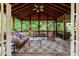 Cozy screened porch with wood ceiling, ceiling fan, and comfortable wicker furniture at 745 Devon Hill Ct, Roswell, GA 30075