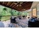 Spacious covered deck with wood ceiling, ceiling fans, and comfortable seating areas at 745 Devon Hill Ct, Roswell, GA 30075