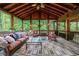 Cozy screened porch with wood ceiling, ceiling fan, and comfortable wicker furniture at 745 Devon Hill Ct, Roswell, GA 30075