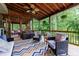 Spacious covered deck with wood ceiling, ceiling fans, and comfortable seating areas at 745 Devon Hill Ct, Roswell, GA 30075