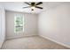 Comfortable bedroom features a ceiling fan, neutral carpet, and a view from the window at 45 Pine Tree Dr, Mcdonough, GA 30252