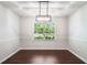 Dining room featuring tray ceiling, hardwood floors, a modern lighting fixture and a large window at 45 Pine Tree Dr, Mcdonough, GA 30252