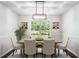 Elegant dining room with a tray ceiling, modern lighting fixture, and a large window offering natural light at 45 Pine Tree Dr, Mcdonough, GA 30252