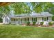 Charming single-story home with a welcoming front porch, lush green lawn, and mature trees providing shade at 45 Pine Tree Dr, Mcdonough, GA 30252