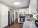Spacious kitchen featuring stainless steel appliances, white cabinetry, granite counters and view of the dining nook at 45 Pine Tree Dr, Mcdonough, GA 30252