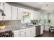 Kitchen with granite countertops, stainless steel appliances, white cabinetry, and view of the dining nook at 45 Pine Tree Dr, Mcdonough, GA 30252