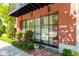 The entrance to the property, featuring expansive windows, meticulous landscaping, and a charming brick sidewalk at 89 E Andrews Nw Dr, Atlanta, GA 30305