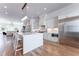 Modern white kitchen featuring an island with bar seating, stainless steel appliances, and hardwood floors at 89 E Andrews Nw Dr, Atlanta, GA 30305