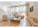 Comfortable living room featuring a brick wall, neutral-toned sofa, natural light, and stylish decor at 89 E Andrews Nw Dr, Atlanta, GA 30305