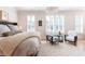 Bright main bedroom with plush bed, sitting area, and white window shutters at 89 E Andrews Nw Dr, Atlanta, GA 30305