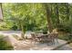 Backyard view featuring outdoor dining on a concrete patio shaded by mature trees at 1178 Roxboro Ne Cv, Atlanta, GA 30324