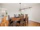 A dining room with a dark wood table and modern light fixture with a sliding door to the kitchen at 1178 Roxboro Ne Cv, Atlanta, GA 30324